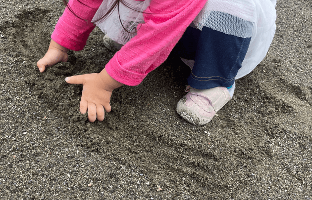 濡れた砂場で遊ぶ子ども